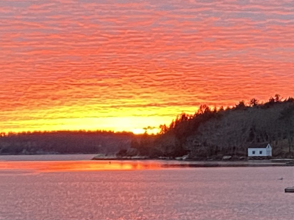 Brilliant sunset with pink mackerel sky reflected in water